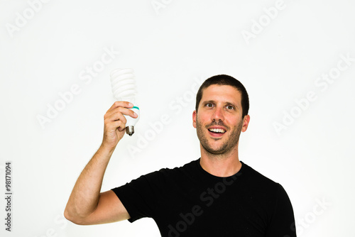 close-up of young caucasian man having a brillant idea holding an energy save bulb in his hand - conceptual image isolated on white background