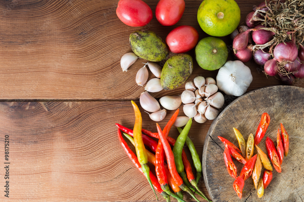 Thailand Food Ingredients: Tomatoes, peppers, garlic, shallots, lemon, olive with a mortar on a wooden floor. Thailand Food Ingredients: Tomatoes, peppers, garlic, shallots, lemon, olive with a mortar on a wooden floor.