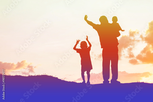 father encouraged her son outdoors at sunset, silhouette concept