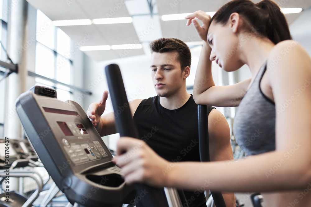 woman with trainer exercising on stepper in gym woman with trainer exercising on stepper in gym