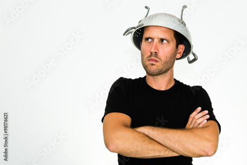 Cuadro en lienzo close-up of angry young caucasian man with a colander on his head and arms cross