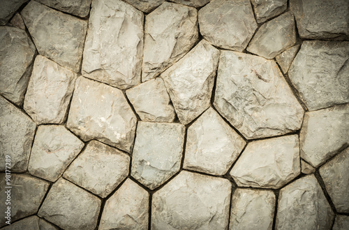 Closeup old stone wall in the garden texture background in vintage tone