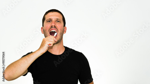 close-up of young caucasian man brushing his teeth - isolated on white background with copyspace