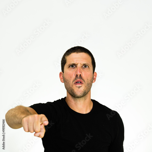 Close up of angry young caucasian man pointing at you - isolated on white background
