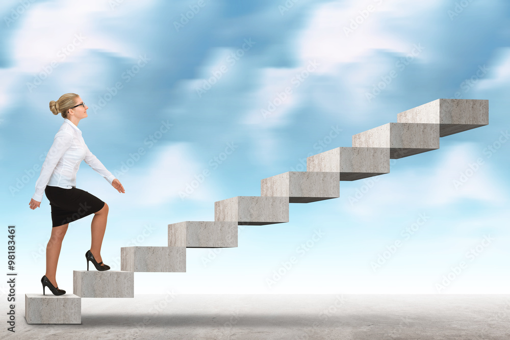 Business woman walking up a staircase.
