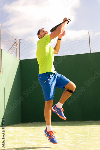 Man jumping while playing Tennis