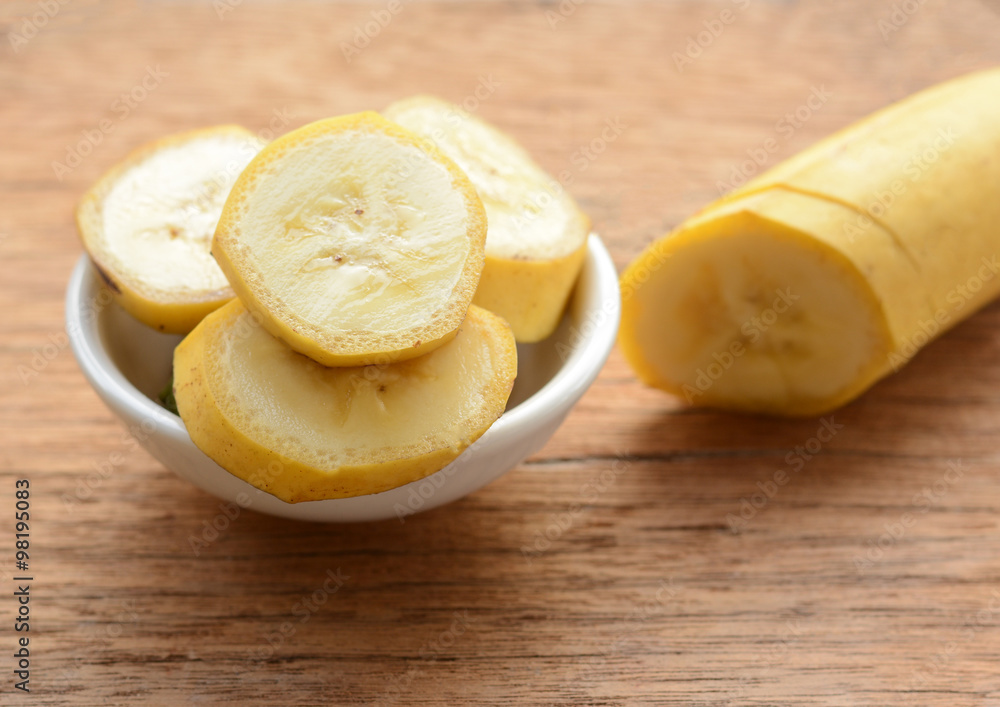 sliced banana in a cup over a table.