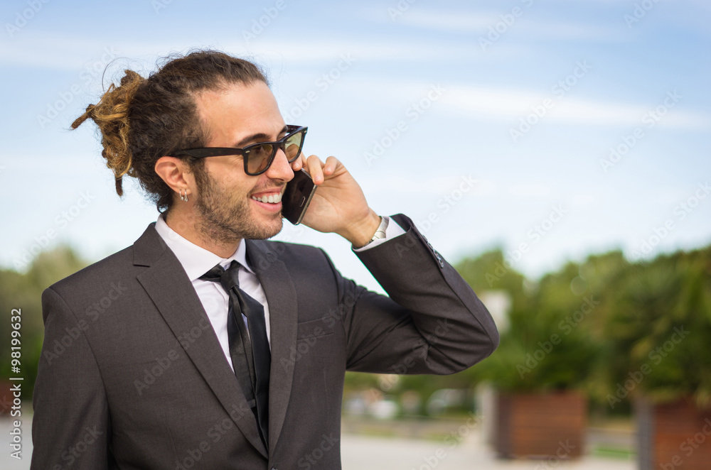 Handsome business man is talking and smiling with his smartphone Handsome business man is talking and smiling with his smartphone
