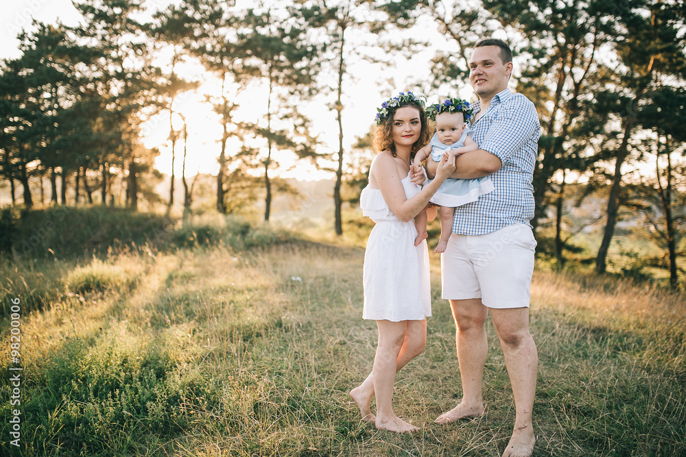 Happy family of mother father and lovely daughter in sunset light. Happy family of mother father and lovely daughter in sunset light.