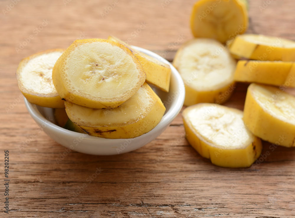 sliced banana in a cup over a table.