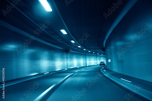 Motion blurred blue colored tunnel high speed car driving. Motion blur visualizes the speed and dynamics. Personal perspective used.
