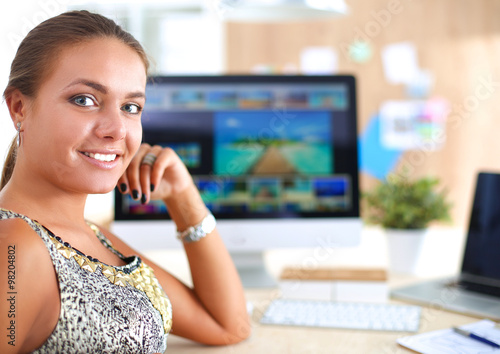 Young woman working in office, sitting at desk