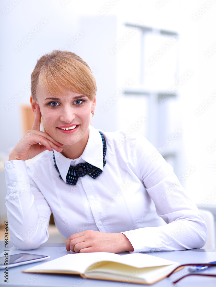 Portrait of businesswoman sitting at desk with a laptop Portrait of businesswoman sitting at desk with a laptop