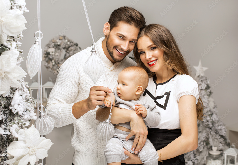 Beautiful happy familly hugging cute child in Christmas scenery Beautiful happy familly hugging cute child in Christmas scenery