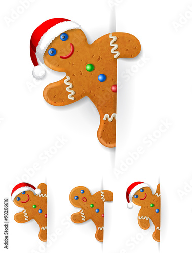 set of Christmas gingerbread mans looks out from behind a vertical white paper sheet