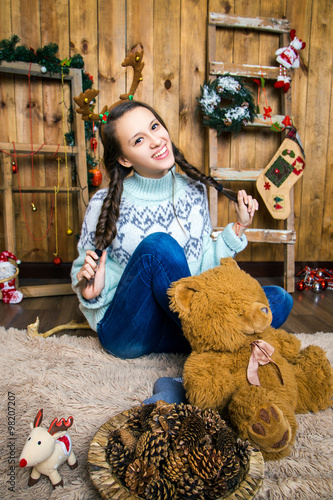 girl with toy bear isitting in the room with wooden walls photo