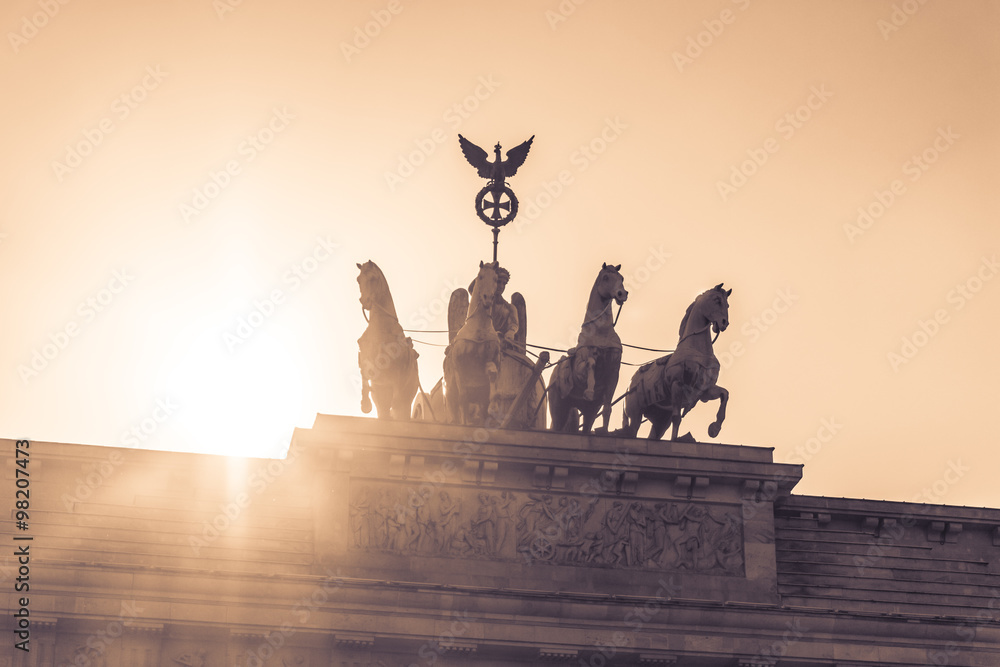 Fototapeta premium Brandenburg gate quadriga sight in berlin city germany europe. Sunset behind the german symbol and landmark Brandenburger Tor at Pariser Platz in the german capital berlin city.