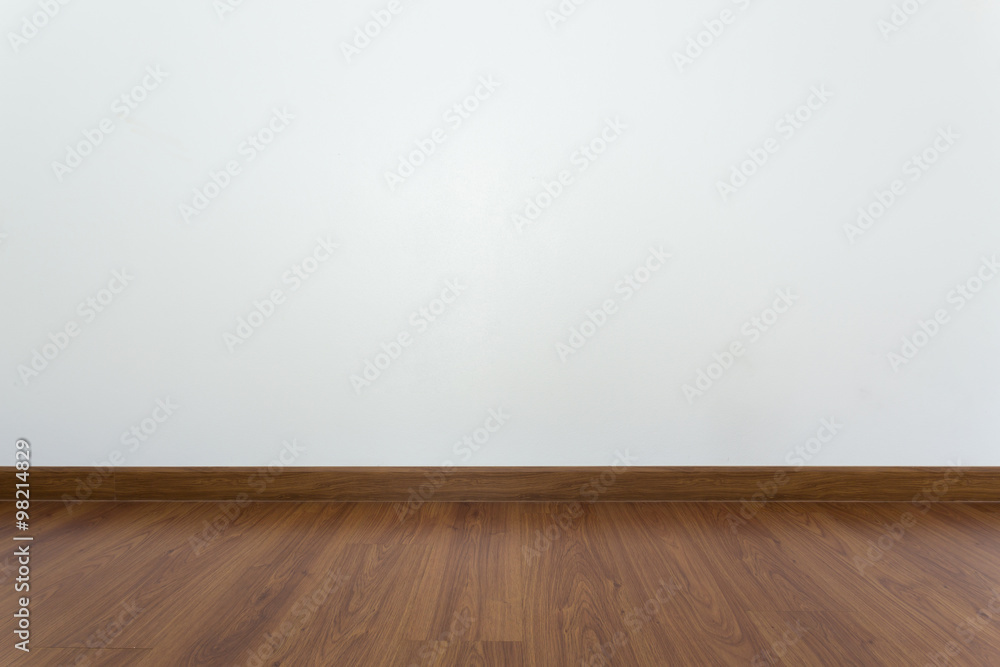 empty room with brown wood laminate floor and white mortar wall empty room with brown wood laminate floor and white mortar wall