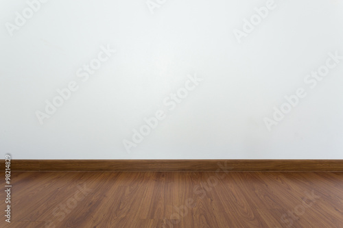empty room with brown wood laminate floor and white mortar wall