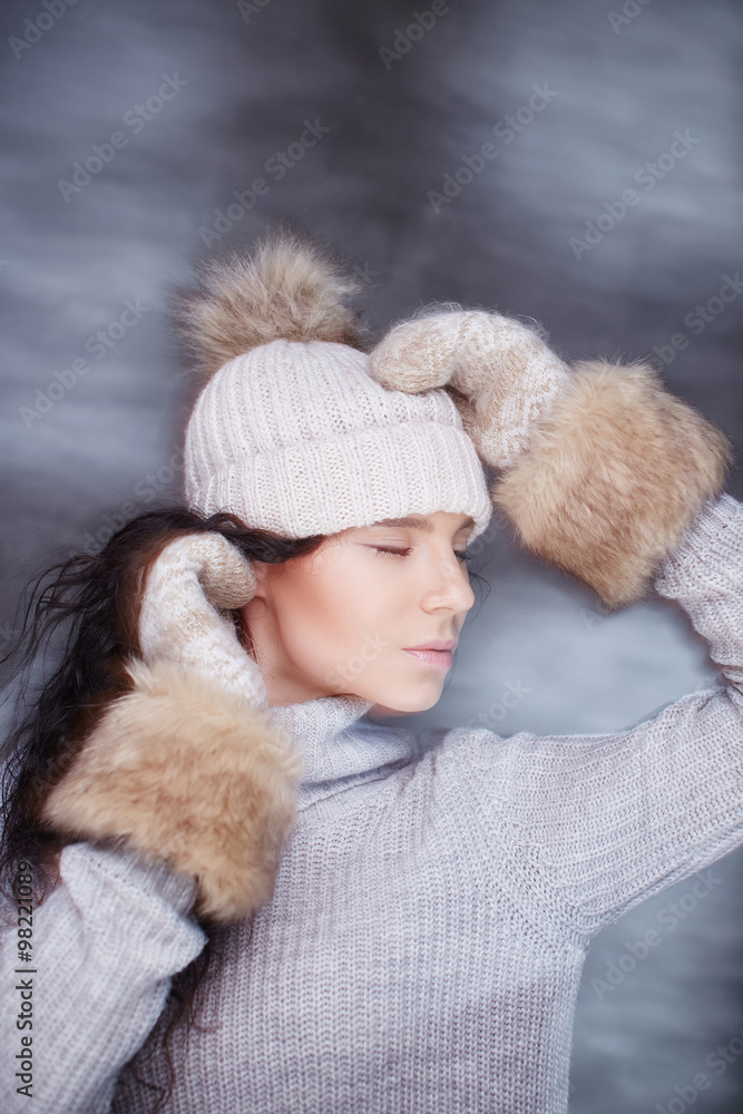 Brunette woman in warm winter hat and fur gloves.