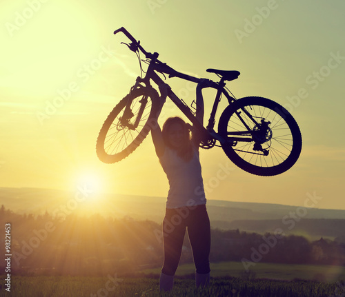 Girl with bicycle in the sunset