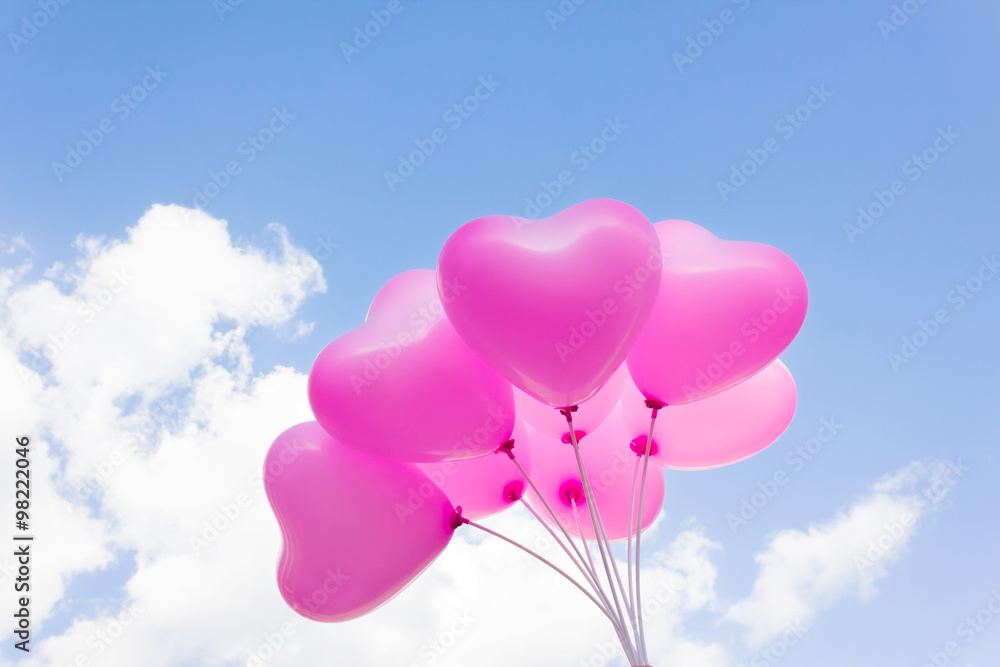 Group of lovely pink heart pattern balloons on blue sky