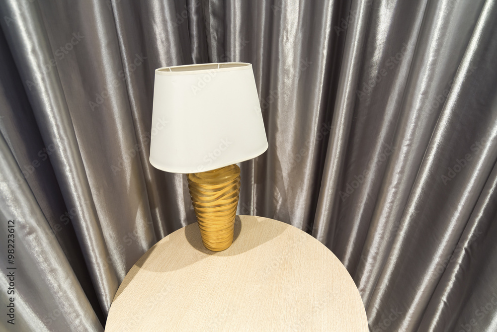 Table lamp by curtains in room