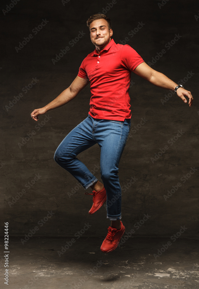 Jumping young man in jeans and red t shirt.