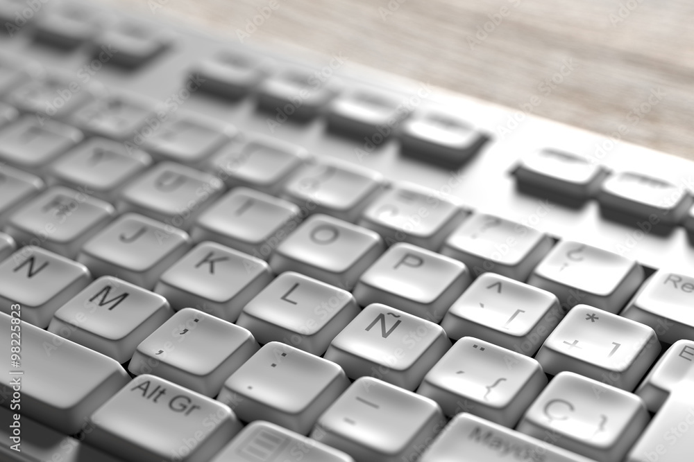 Close-up of white spanish keyboard on wooden table Close-up of white spanish keyboard on wooden table