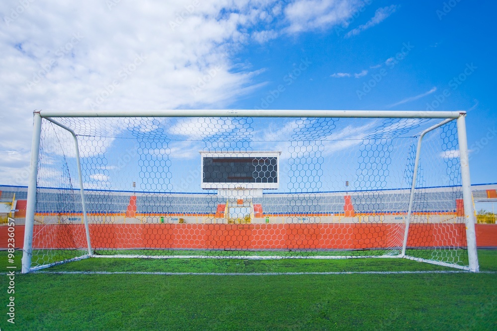Fototapeta premium STADIUM - Football field with goal and tablo on blue sky