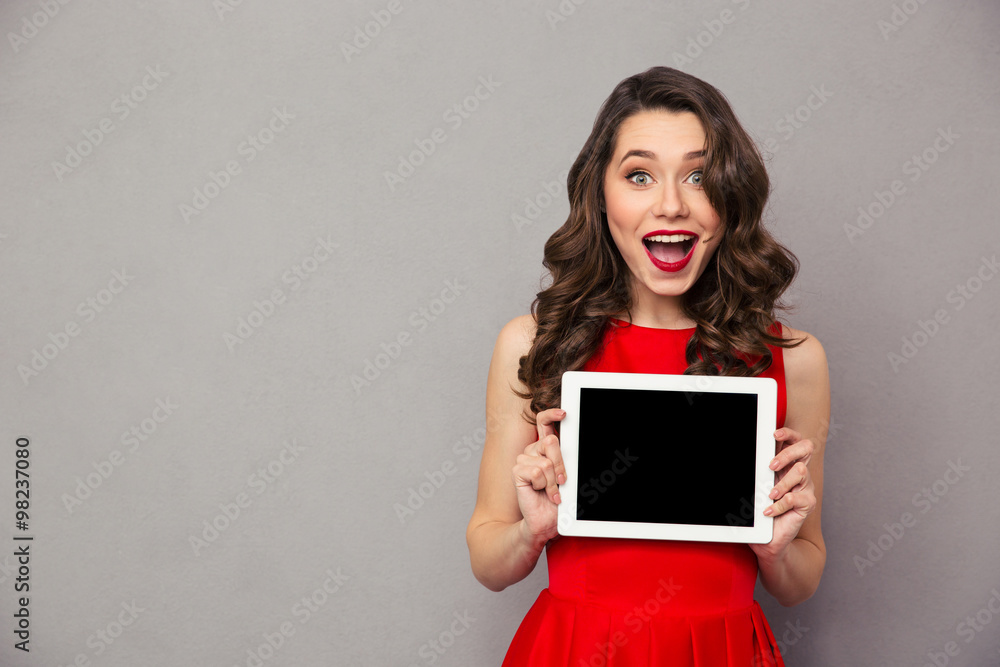 Woman in red dress showig blank tablet computer screen Woman in red dress showig blank tablet computer screen