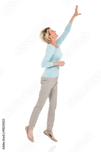 senior woman jumping up and reaching out