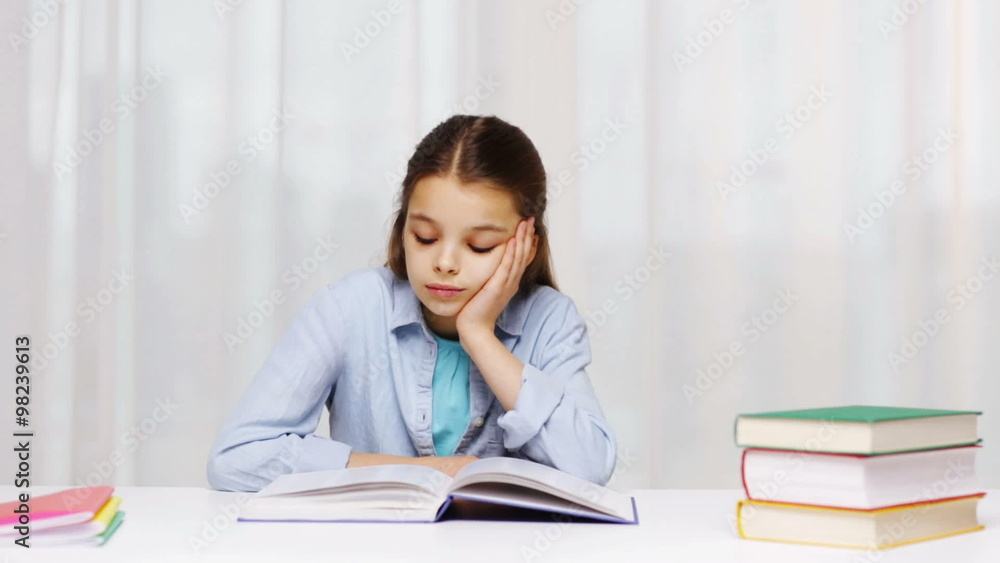 bored school girl reading book or textbook at home bored school girl reading book or textbook at home