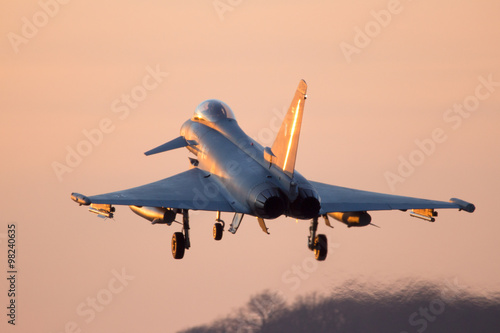 Fighter jet landing at sunset photo