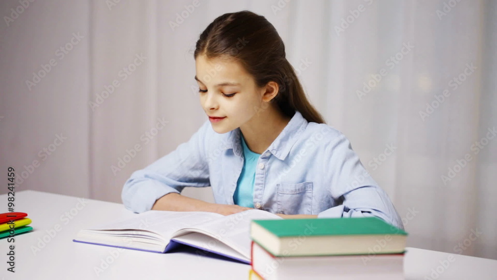 happy school girl reading book or textbook at home happy school girl reading book or textbook at home