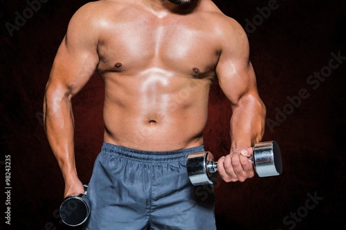 Composite image of mid section of a bodybuilder with dumbbells