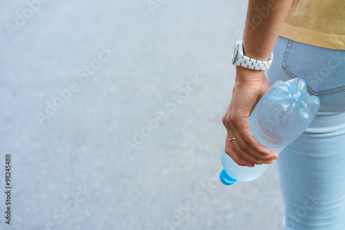 Female hand holding a plastic water bottle