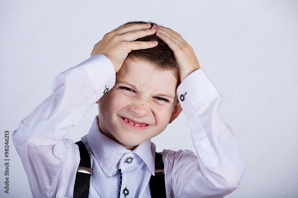Stressed little boy having problems.Confused little boy with hand on his had over grey background.Stressed little boy having problems. Stressed little boy having problems.Confused little boy with hand on his had over grey background.Stressed little boy having problems.