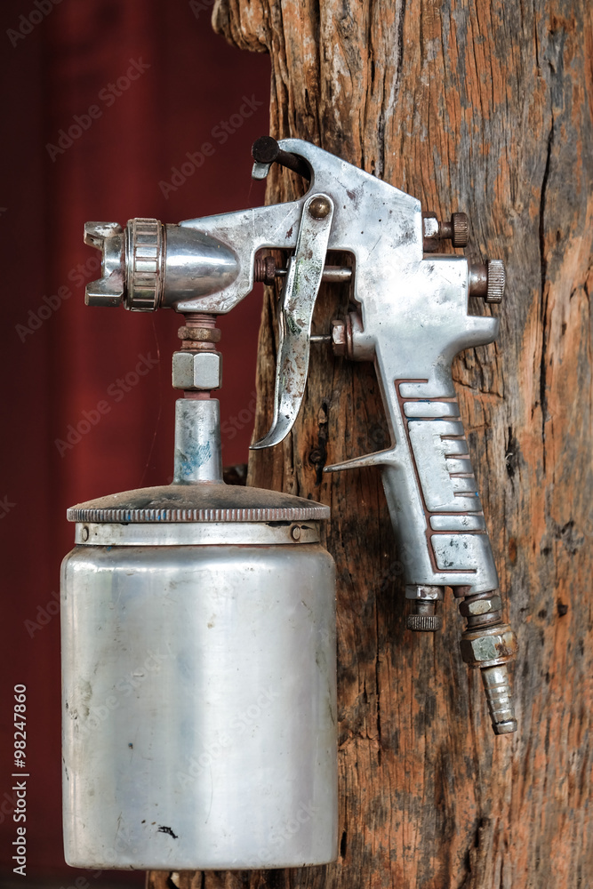 Spray paint gun hanging on wood Spray paint gun hanging on wood