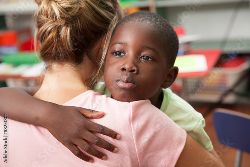 Teacher and boy hugging 