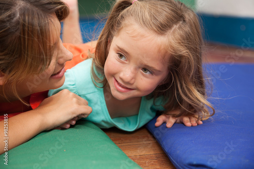 teacher playing on the floor with a litlle girl