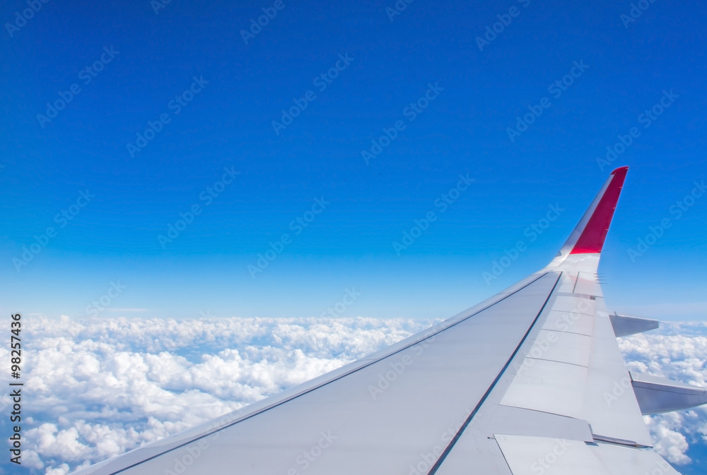 Clouds and blue sky as seen through window of an aircraft Clouds and blue sky as seen through window of an aircraft