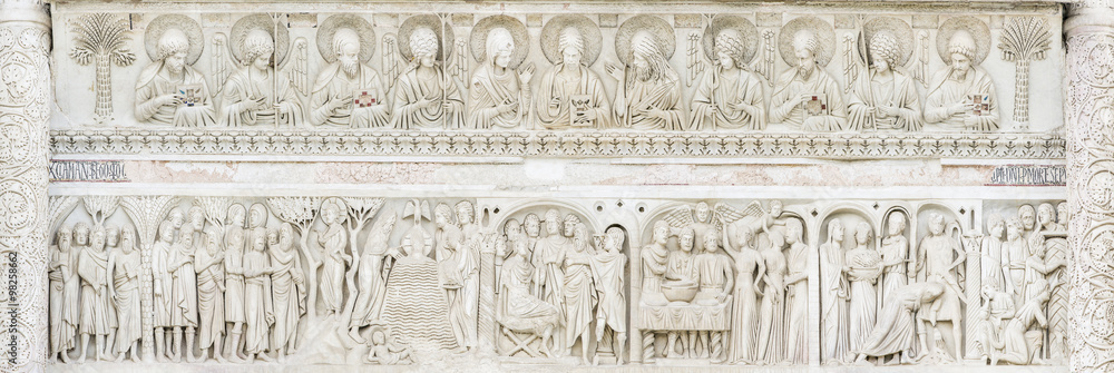 sculptures from marble on the bas above the door of cathedral in Pisa in Italy