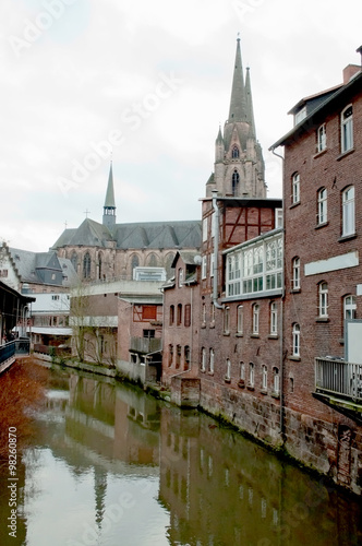 Old brick houses and a church near the water channel in the historical center of Marburg, Germany