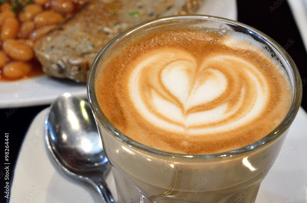 A cup of coffee with heart pattern in a white cup.. A cup of coffee with heart pattern in a white cup..