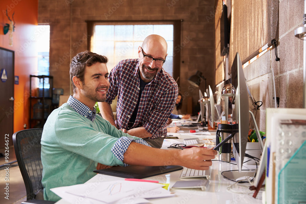 Designers Working Together At Desks In Modern Office Designers Working Together At Desks In Modern Office