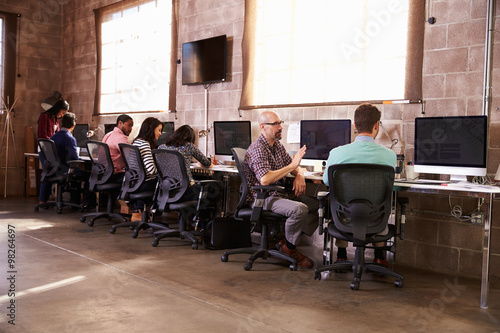 Team Of Designers Working At Desks In Modern Office
