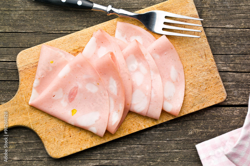 Slices of Sausage Mortadella on cutting board photo