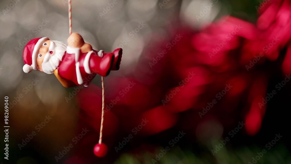 Un père noël de décoration grimpe à la corde au sapin