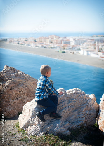 little boy sitting on the rocks